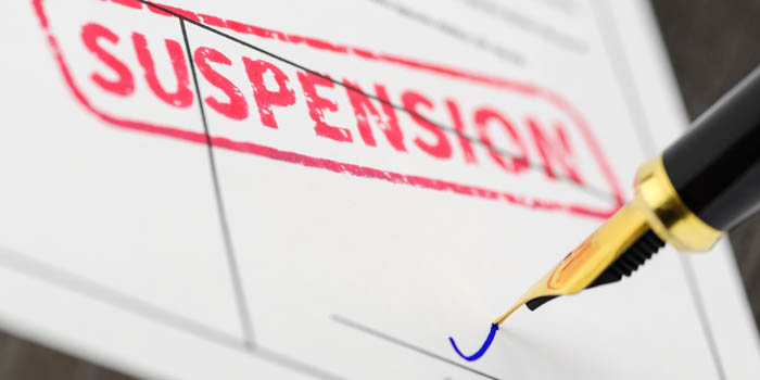Person signs a suspension document