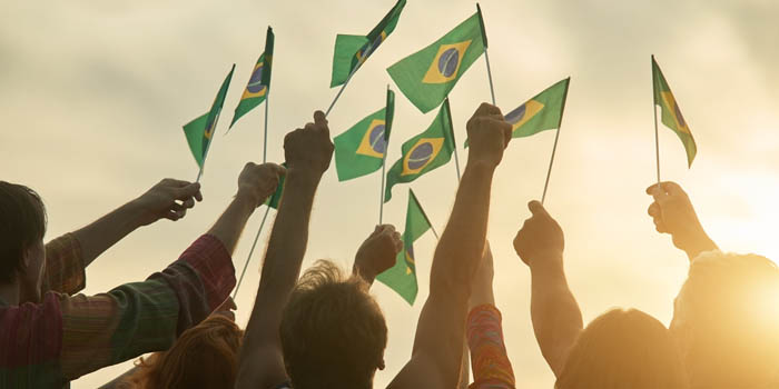 People waving multiple Brazilian flags